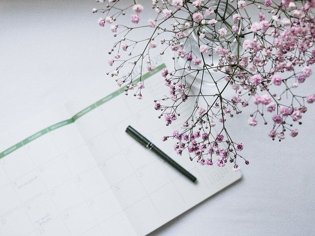 Calendar with pen and flowers