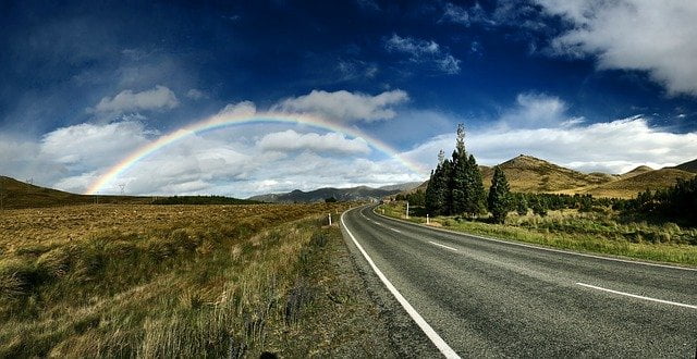 Rainbow over scenic countryside road