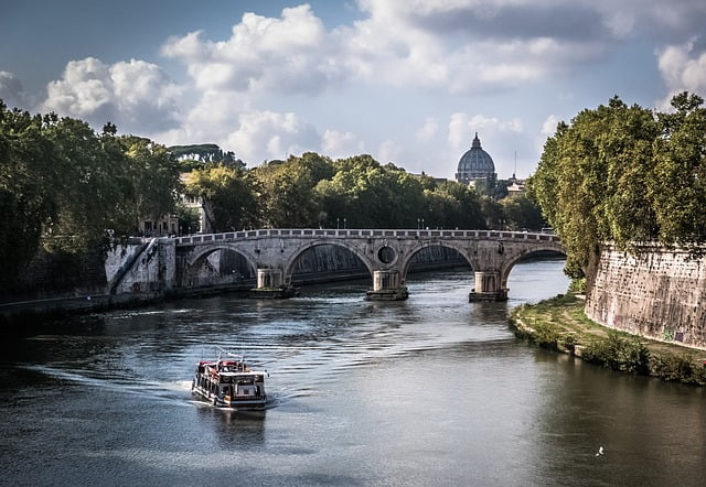 Rome bridge views with a boat on the water in Italy