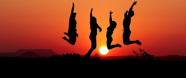 Friends jumping during sunset