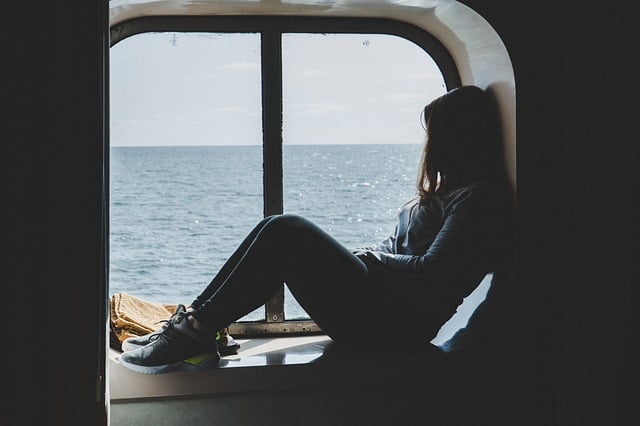 Woman looking out window of cruise ship